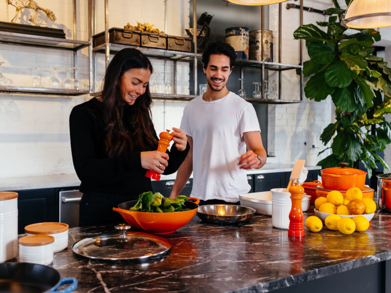 A man and woman make a salad in a couples cooking class.